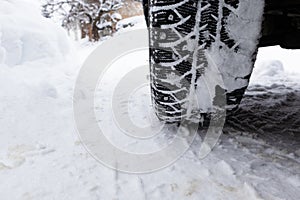 Closeup winter tire. Car tires on the road covered with snow.