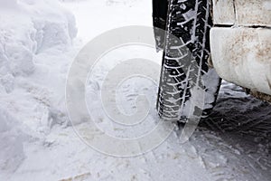 Closeup winter tire. Car tires on the road covered with snow.