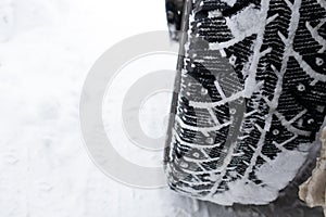 Closeup winter tire. Car tires on the road covered with snow.