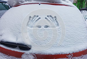 Closeup of wipers and frosted car windshield covered with ice and snow. Winter weather.