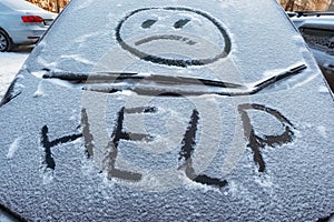 Closeup of wipers and frosted car windshield covered with ice and snow. Winter weather, transportation concept