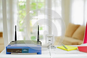 closeup of a wireless router and ip camera on living room at home with a window in the background