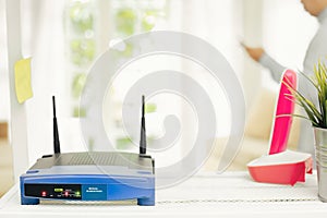 closeup of a wireless router on living room at home with a window in the background