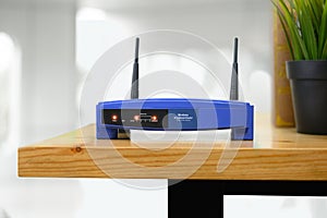 Closeup of a wireless router and a man using smartphone on living room at home ofiice
