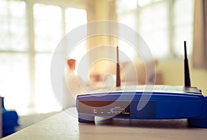 Closeup of a wireless router and a young man using Laptop