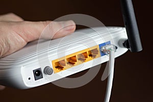 closeup of a wireless router and a young man using a smartphone on living room at home