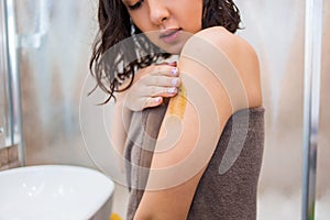 Closeup of woman applies on the body, hands scrub, mask, lotion