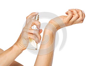 Closeup on woman applying perfume on hand