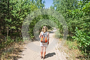 Closeup of woman with backpack on trailway in fir and pine trees forest. Concept of active lifestyle, hiking and tourism