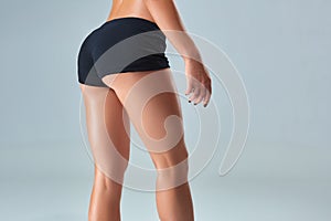 Closeup woman beautiful buttocks over grey background