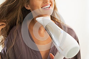 Closeup on woman blow drying hair