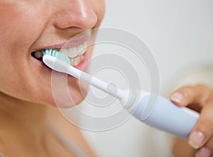 Closeup on woman brushing teeth