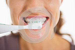 Closeup on woman brushing teeth