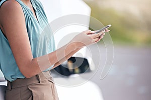 Closeup woman calling roadside assistance. Hands of a young woman dialling for help after a vehicle breakdown. Having