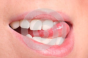 Closeup of woman chewing lips