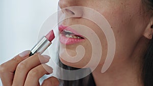 Closeup woman colouring lips at home. Happy smiling lady enjoying makeup care