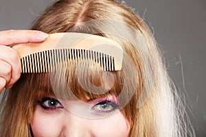 Closeup woman combing her fringe with comb