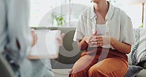 Closeup, woman on a couch and therapy with conversation, healing and trauma with questions and clipboard. Closeup