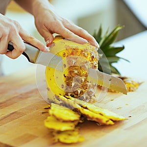 Closeup on woman cutting pineapple