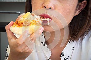 Closeup woman eating pizza. Closeup on face and mouth.