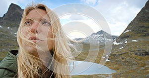 Closeup of woman enjoying mountain view after hiking, traveling or exploring remote Norway landscape. Slow motion