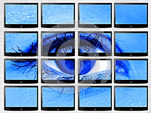 Closeup Woman Eye on video wall of multiscreen flat tv techonology concept of blue filter for health photo