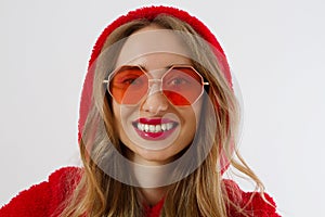 Closeup woman face in red sunglasses isolated on white background. Girl in red hoodie sweatshirt and red lips makeup. Fashion