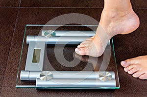 Closeup of woman foot uploading to bathroom scale