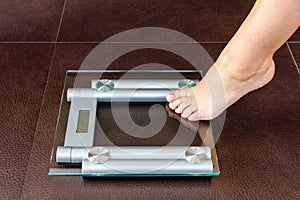 Closeup of woman foot uploading to bathroom scale