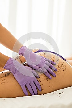 Closeup of a woman getting a whole-body relaxing scrub massage done in a spa