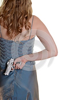 Closeup woman with gun behind back