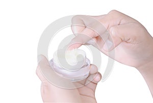 Closeup woman hand applying cream or moisturizer from box  on white background, selective focus