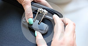 Closeup woman hand closes or opens suitcase bag with combination lock