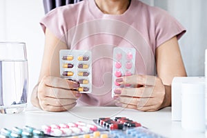 Asian woman comparing and being confused between antibiotic and antibiotic anti-inflammatory medication photo