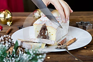 Woman hand cut christmas chocolate cake with holiday decoration. Food xmas background.