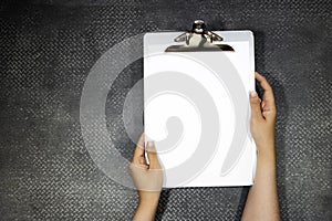 Closeup woman hand holding a classic metal clipboard with blank white paper isolated