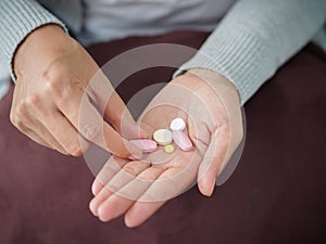 Closeup woman hand holding a pill.