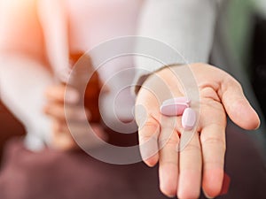 Closeup woman hand holding a pill.