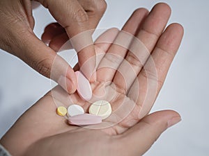 Closeup woman hand holding a pill.