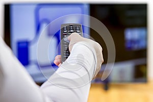 Closeup on woman hand holding remote control