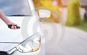 Closeup woman hand holding the remote control car alarm systems