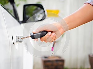 Closeup woman hand holding the remote control car alarm systems.