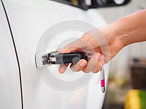 Closeup woman hand holding the remote control car alarm systems.