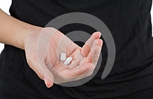 Closeup woman hand holding white pills