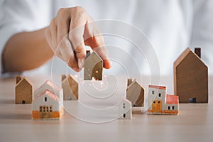 Closeup woman hand holding wooden home model