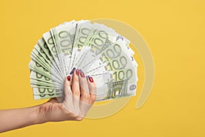 Closeup of woman hand showing fan of euro banknotes, arm holding cash, lot of money and wealthy life