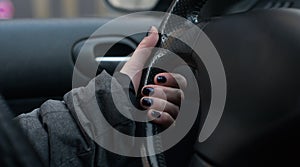 Closeup of woman hand on the steering wheel