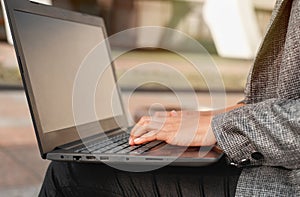 Closeup of woman hand typing on laptop keyboard