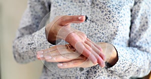 Closeup of woman hands applying moisturizer