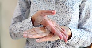 Closeup of woman hands applying moisturizer